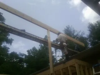 Carpenter setting a ridge beam over a new addition frame — Ice Dam Removal by Roofing Brothers in Kunkletown