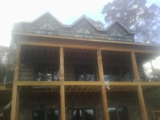 Dormers and porch framing on a large log home under construction — Roof Coating work by our crew in Kunkletown