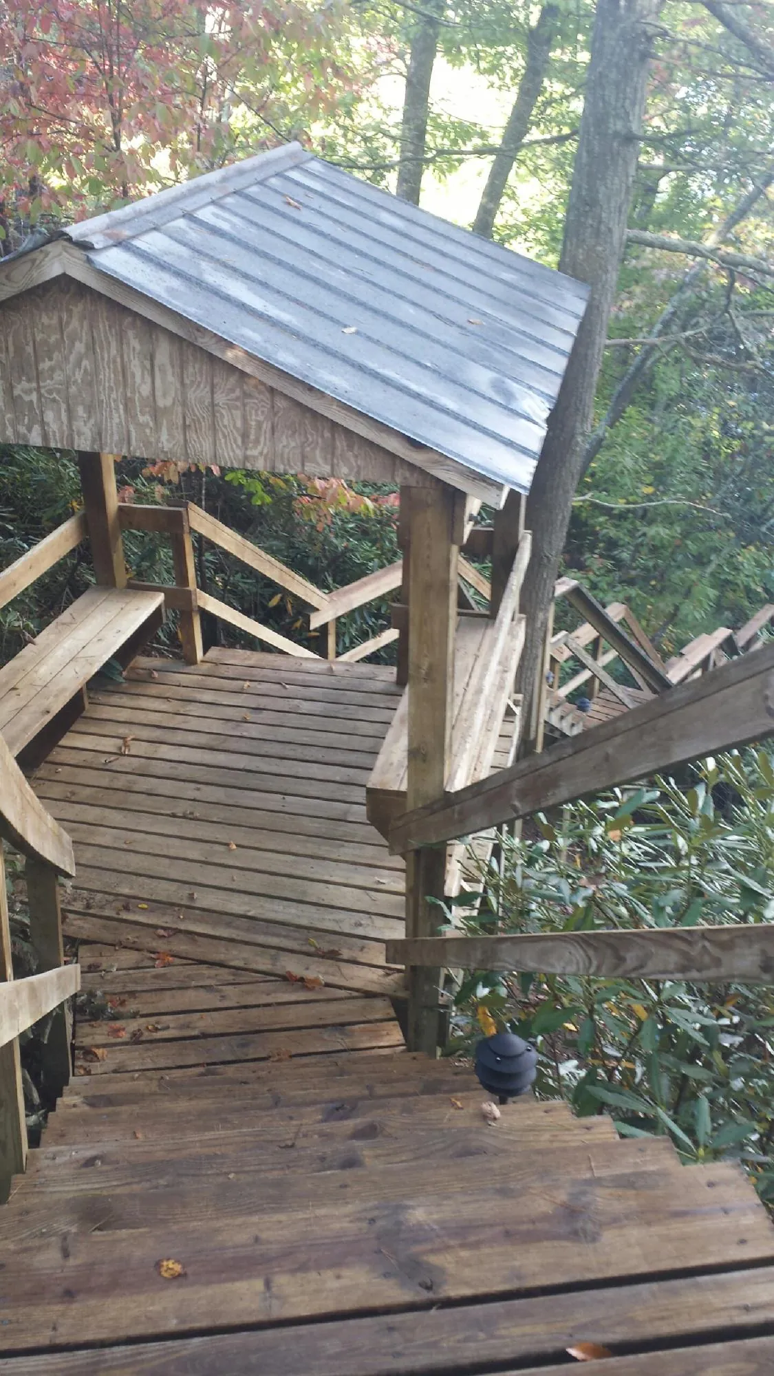 Metal roofed shelter over wooden steps on a wooded walkway — Skylight Repair & Installation work by our crew in Kunkletown